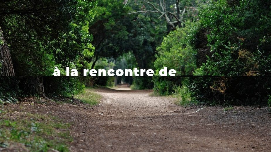 Un chemin de terre dans une forêt "à la rencontre de" est écrit en blanc au centre de l'image